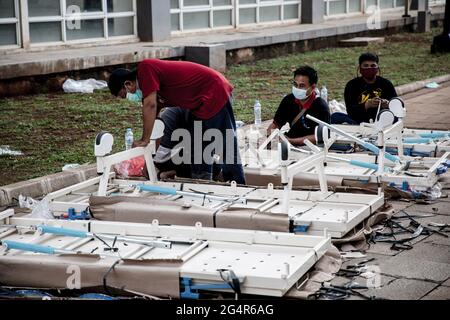 Centro di Giacarta, Indonesia. 21 Giugno 2021. I lavoratori sono visti fissare i letti all'interno del complesso ospedaliero di emergenza Wisma Atlet Covid-19. L'Ospedale di emergenza Wisma Atlet Covid-19 con 7,394 letti è quasi il 90% riempito. L'Indonesia ha registrato un picco significativo nei casi COVID-19 dopo la vacanza Eid durante l'ultimo mese. Il numero dei casi di Covid-19 è stato superato di due milioni. (Foto di Ria Krisadhi/SOPA Images/Sipa USA) Credit: Sipa USA/Alamy Live News Foto Stock