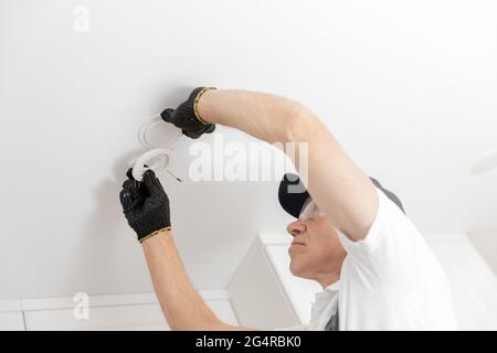 Closeup Electrician install sostituisce la lampada a LED a casa. Foto Stock