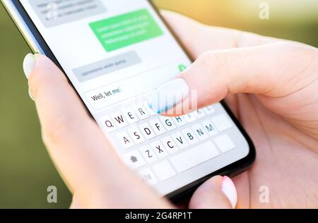 Messaggio di testo con telefono cellulare. Donna SMS con smartphone Catfish o truffa digitale. Tastiera su schermo nella chat di messaggistica istantanea. Primo piano della macro. Foto Stock