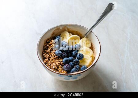 Granola con mirtilli, banana e burro di arachidi yogurt o yogurt. Pronto a servire e mangiare. Foto Stock