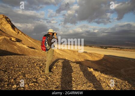 Splendidi colori e nuvole, escursionista, un adulto anziano (60 anni) fotografie al tramonto Arava Valley, parte della Jordan Valley nella Rift Valley, Israele. Foto Stock