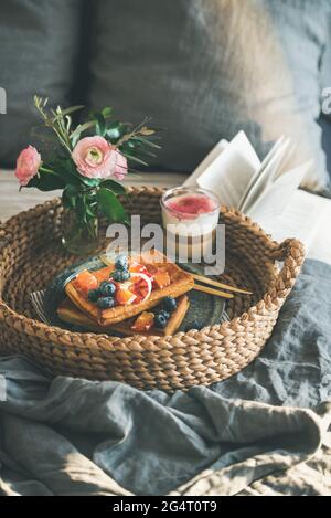 Waffle con arancia e mirtilli, latte di rosa in vetro Foto Stock