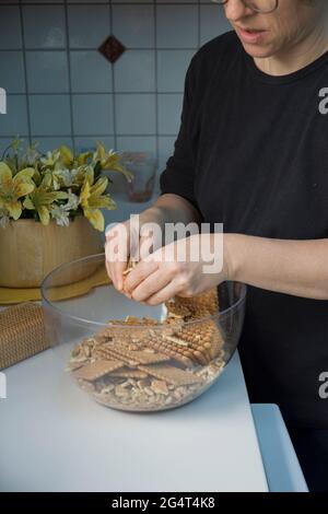 Lei sta sgretolando i biscotti. Sta facendo una torta di compleanno con biscotti e cioccolato. Torta a mosaico. Buon compleanno. Foto Stock