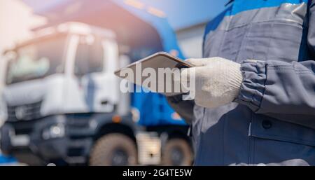 Banner di concetto online logistico automatizzato. Il conducente del dumper in uniforme con il computer tablet controlla il carico di carico o carbone. Foto Stock