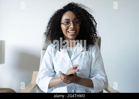 Misto razza donna medico parlare online con il paziente, fare una videochiamata, guardando la fotocamera Foto Stock