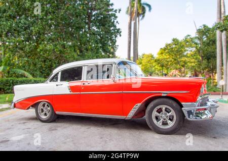 Immagini Cuba: Auto Chevrolet d'epoca rosso-arancio con finiture bianche e cromate e targata Cuba vista laterale. Foto Stock