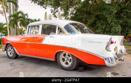 Immagini Cuba: Auto Chevrolet d'epoca rosso-arancio con finiture bianche e cromate e targata Cuba vista laterale. Foto Stock