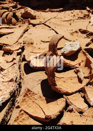 Vista laterale ravvicinata della terra asciutta e incrinata, che inizia ad arricciare Foto Stock