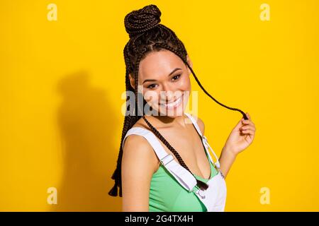 Foto di emozionato affascinante donna pelle scura vestito bianco treccia totale sorridente isolato di colore giallo sfondo Foto Stock