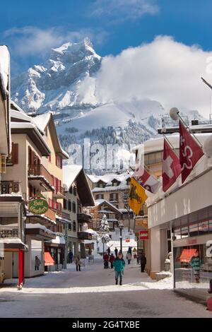 Una vista lungo la strada principale di Engelberg in nevicate invernali con lo sfondo di una montagna, Engelberg, Obvaldo cantone, Svizzera centrale Foto Stock