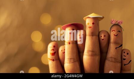 Famiglia creativa felice sulle dita con le luci di bokeh giallo sullo sfondo Foto Stock
