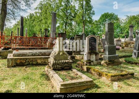 Broumov, repubblica Ceca - 21 maggio 2021. Lapidi e tombe in stile rinascimentale e Impero in vecchio cimitero con la chiesa di Santa Maria in legno dal 13 ° secolo Foto Stock