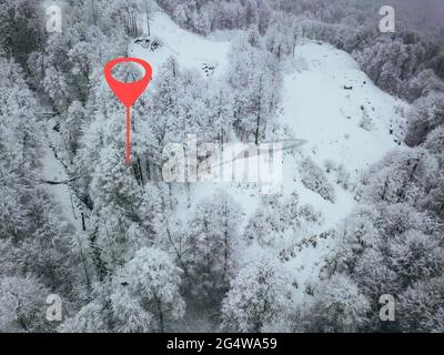 punto di geotag sulla strada da qualche parte in montagna. alberi ricoperti di neve. vista aerea Foto Stock