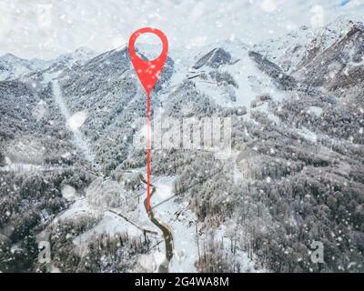 punto di geotag sulla strada da qualche parte in montagna. alberi ricoperti di neve. vista aerea Foto Stock