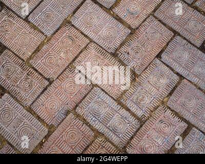 Finitrici in mattoni con cerchi concentrici decorativi intagliati e linee a spina di pesce lungo una passerella a Columbus, Ohio. Foto Stock