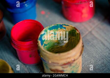 molti piccoli vasi di vernice con colori diversi su una superficie di legno Foto Stock