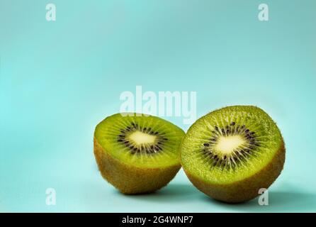 Metà di kiwi maturi su sfondo di menta Foto Stock