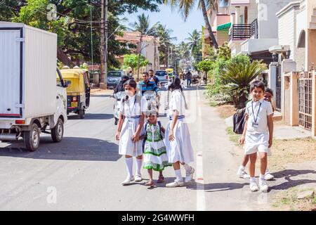 Shy studenti indiani che indossano uniformi bianche provenienti da scuola, Mysore, Karnataka, India Foto Stock