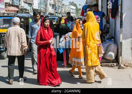 Bella ragazza indiana cammina in giro per l'area musulmana indossando pavimento lunghezza vestito rosso e headdress rosso, Mysore, Karnataka, India Foto Stock