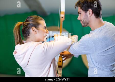 l'uomo e la donna stanno sparando con archi che praticano il tiro con l'arco Foto Stock