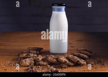 mangiare biscotti al cioccolato mentre si ha un bicchiere di latte Foto Stock