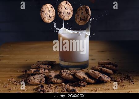 mangiare biscotti al cioccolato mentre si ha un bicchiere di latte Foto Stock