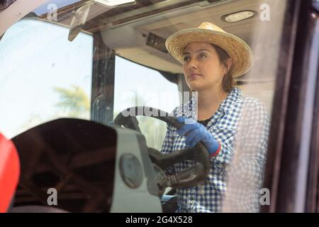 Giovane agricoltore specializzato che guida un trattore piccolo Foto Stock