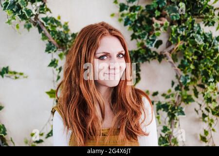 Bella donna rossa di fronte alle piante di vite Foto Stock