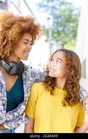 Sorridendo giovani amici femminili che si guardano l'un l'altro Foto Stock
