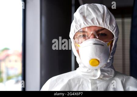 Donna operaio frontline indossare maschera protettiva viso in ufficio Foto Stock