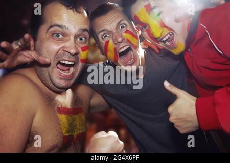 Fan sportivo maschile con vernice a bandiera spagnola sul viso Foto Stock