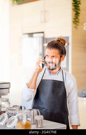 Chef maschile che parla al telefono cellulare nel ristorante Foto Stock