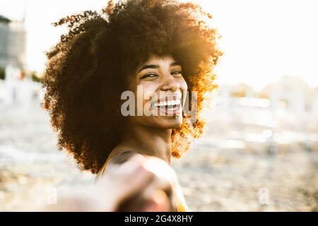 Donna allegra con capelli afro in spiaggia Foto Stock