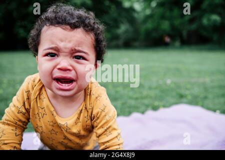 Carino bambino ragazzo piangendo al parco Foto Stock