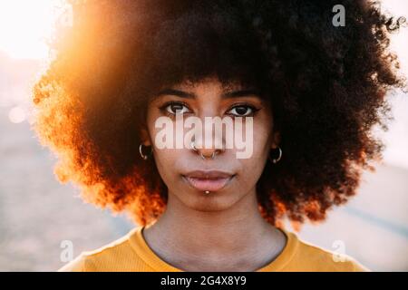 Donna afro con naso trafitto durante il tramonto Foto Stock