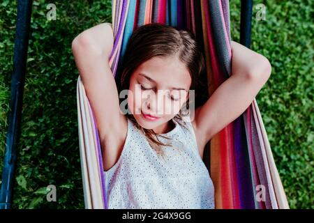 Ragazza con gli occhi chiusi rilassandosi in amaca Foto Stock