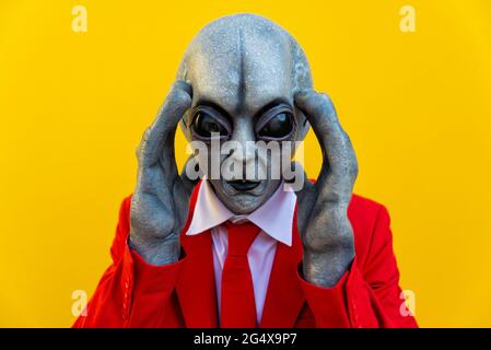 Ritratto di un uomo che indossa un costume alieno e un vestito rosso  brillante che guarda verso la fotocamera Foto stock - Alamy