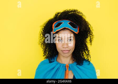 Donna sicura che indossa il costume di supereroe su sfondo giallo Foto  stock - Alamy