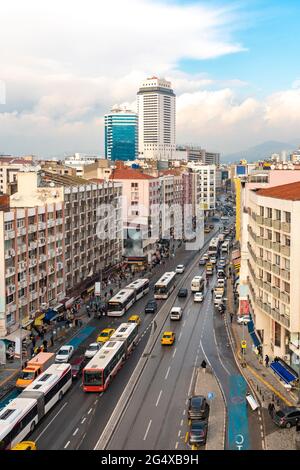 Traffico sulla strada tra edifici moderni a Konak, Smyrna, Izmir, Turchia Foto Stock