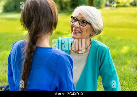 Donna anziana che parla con una donna mid-adulta nel parco pubblico Foto Stock