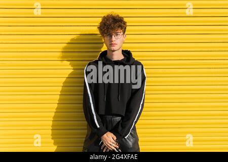 Giovane uomo davanti all'otturatore giallo Foto Stock