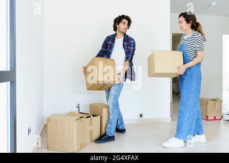 Giovane uomo e donna che porta scatole di cartone in una nuova casa Foto Stock