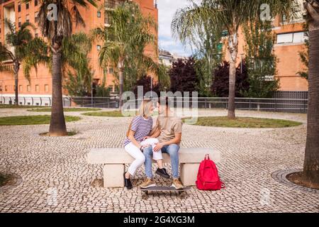 Coppia romantica seduta sul banco in posizione di parcheggio Foto Stock