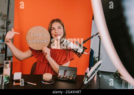 L'influencer femminile adolescente parla con il microfono mentre vlogging a casa Foto Stock