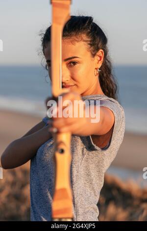 Giovane archeress che punta con arco e freccia Foto Stock