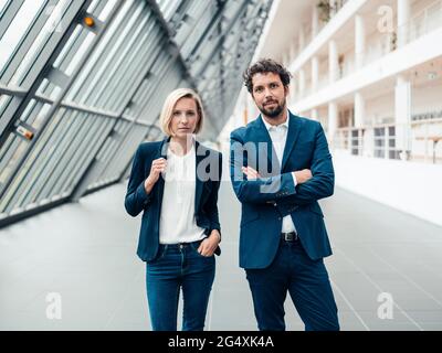 Partner aziendali sicuri che si ereggano nella hall dell'ufficio Foto Stock
