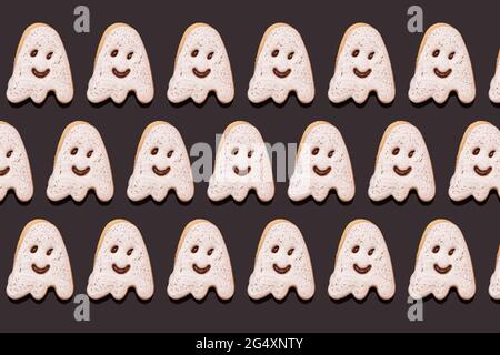 Modello di biscotti al cioccolato a forma di fantasma piatto su sfondo nero Foto Stock