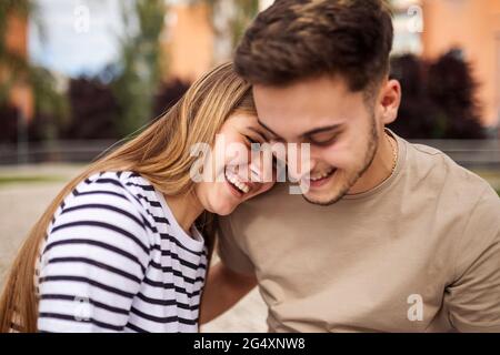 Ragazza sorridente con la testa sulla spalla del ragazzo Foto Stock