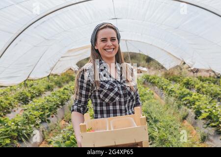 Sorridente agricoltore che lavora in serra Foto Stock