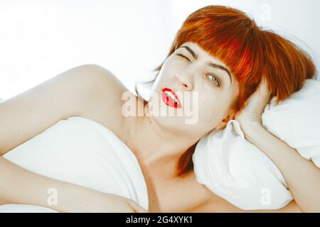 la ragazza si sveglia e sbadiglia. la ragazza con i capelli rossi Foto Stock